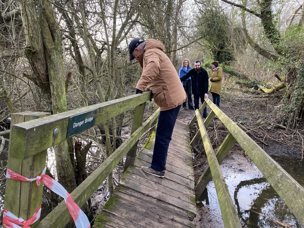 My dad crossing a bridge in Oxford which has tipped onto its side. The sign on it reads “Danger Bridge”. My family look on in horror.