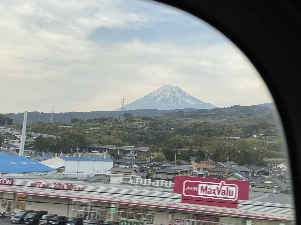 Mt Fuji in the distance seen from a train window.