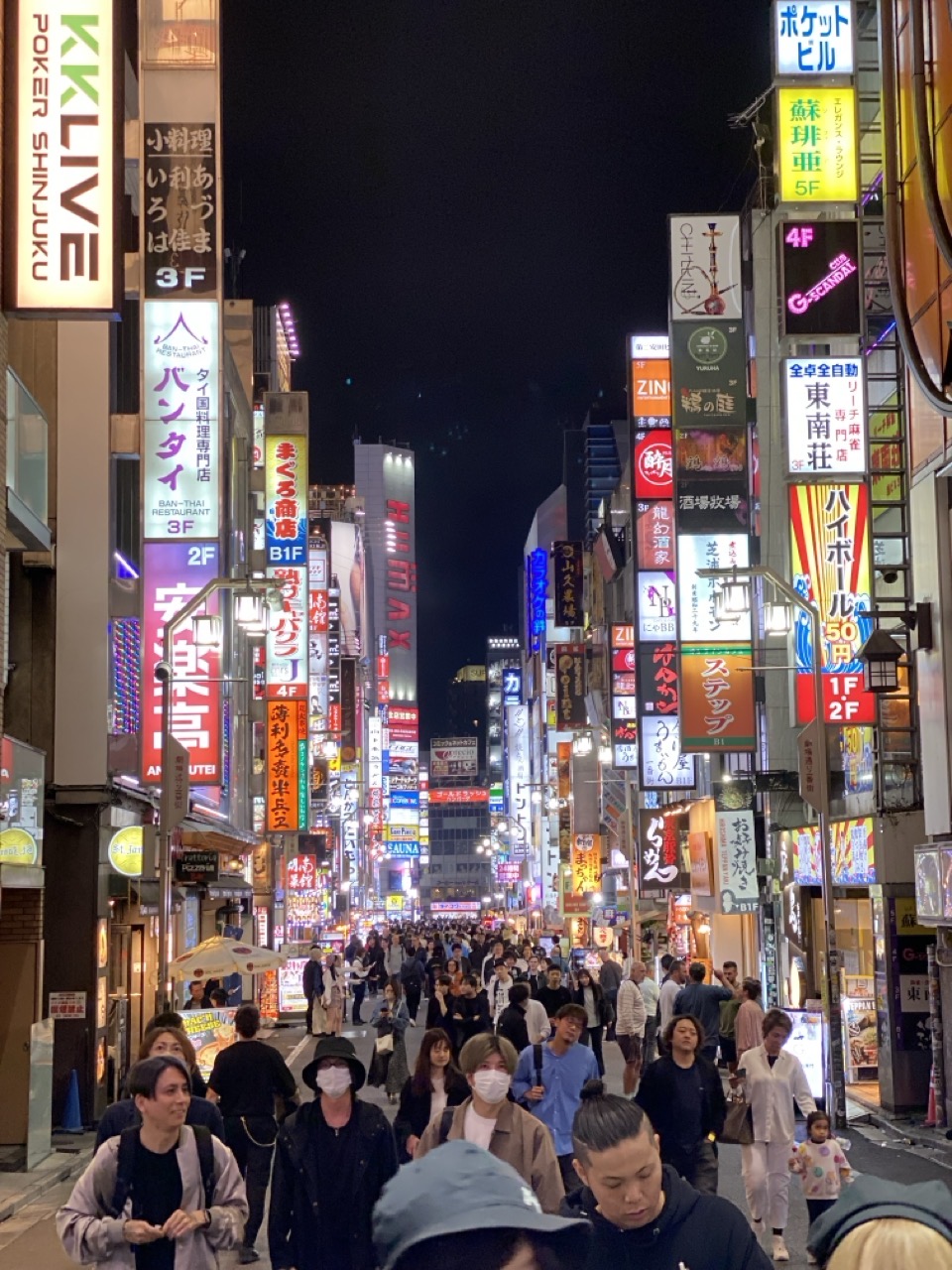 A view of the street with lots of illuminated signs