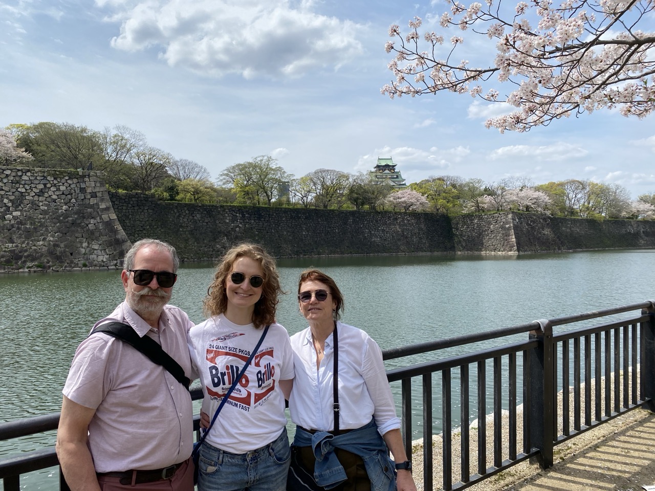 Lucy and her parents, with the castle moat behind and the castle in the distance