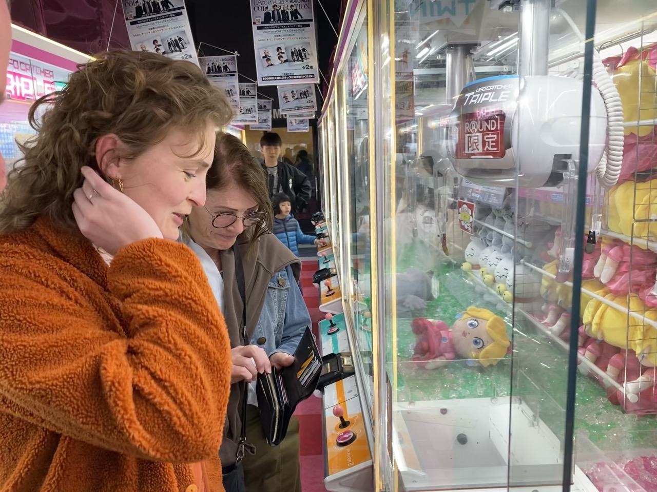 Lucy and her mum trying to win things on the claw machine