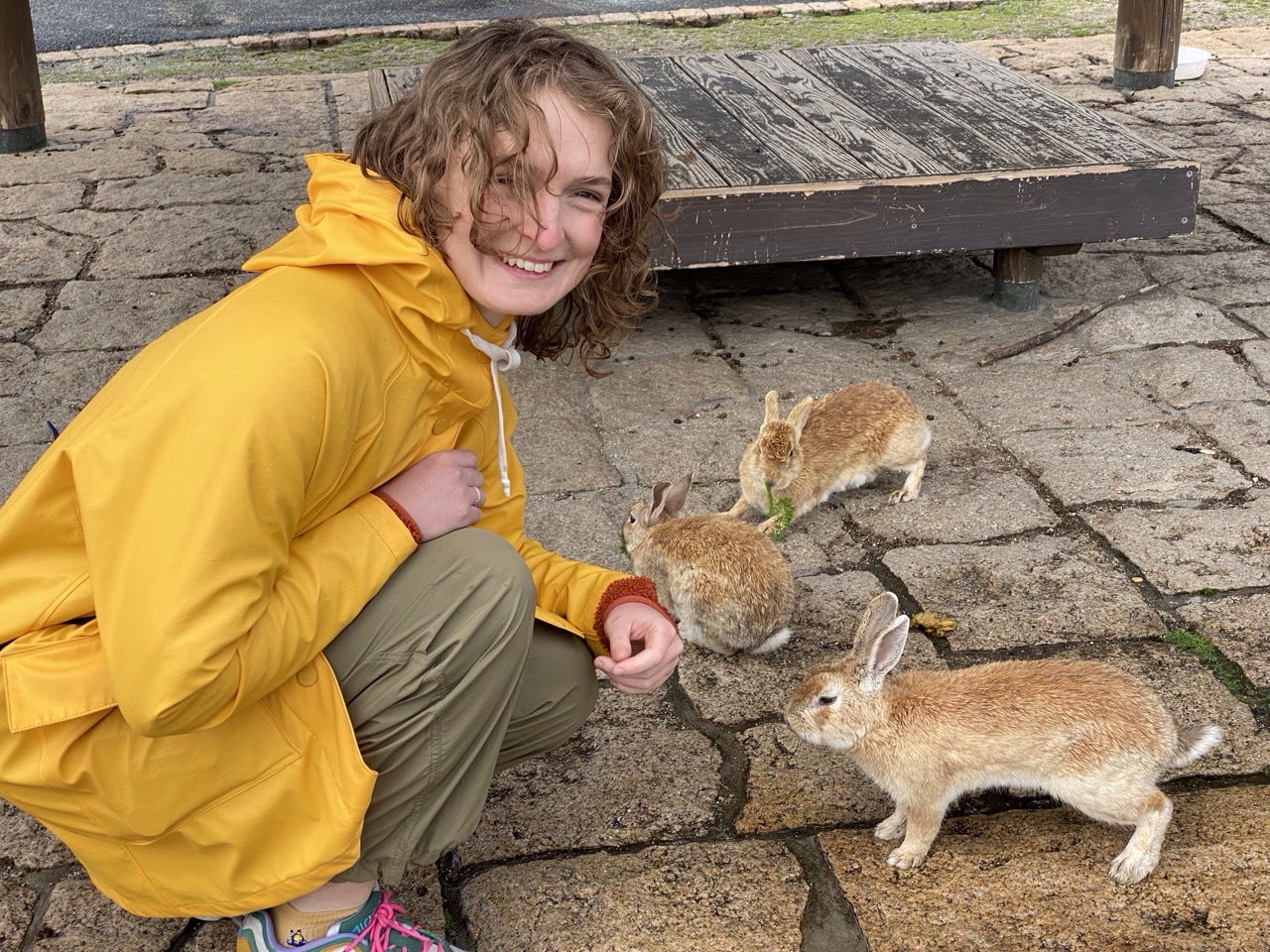 Lucy with lots of rabbits, looking delighted.