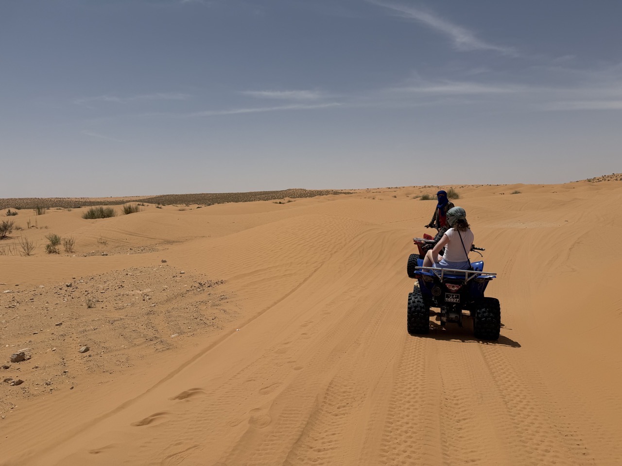 Lucy on a quad bike with the Sahara beyond
