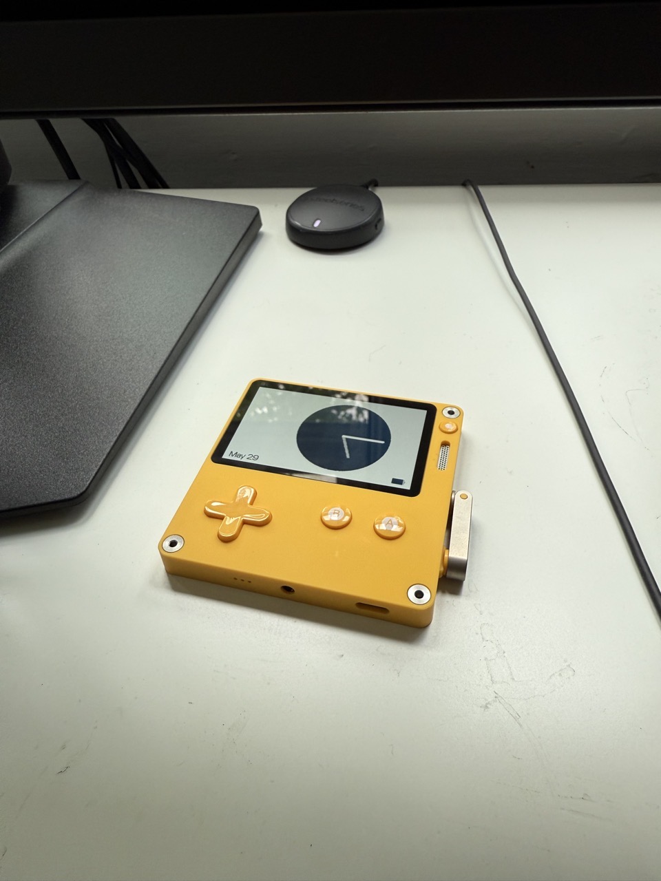A yellow Playdate on a white desk