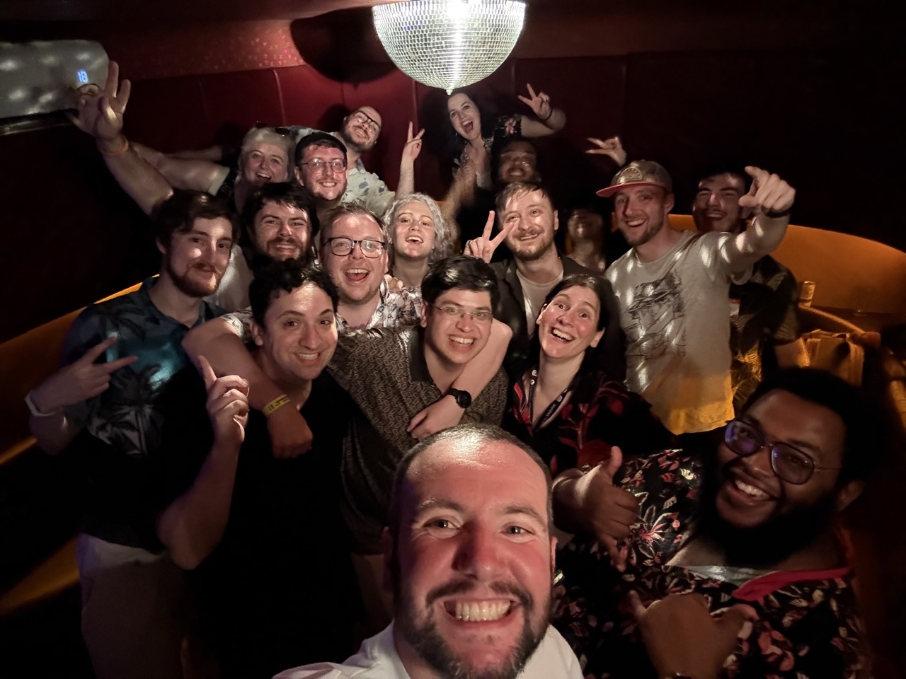 Lots of smiling people in a karaoke booth