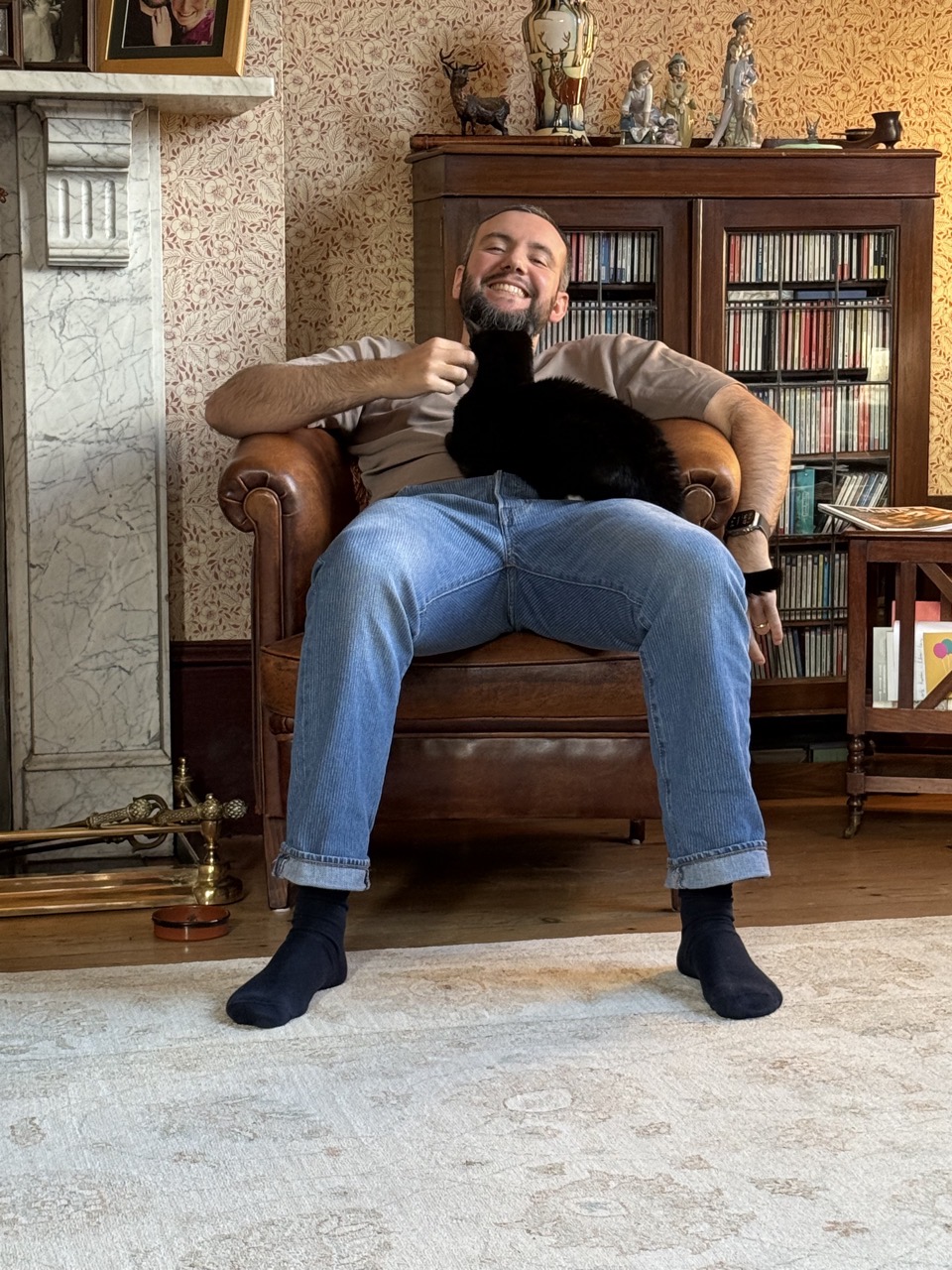 Me on an armchair with a cat sat on me. I look very pleased