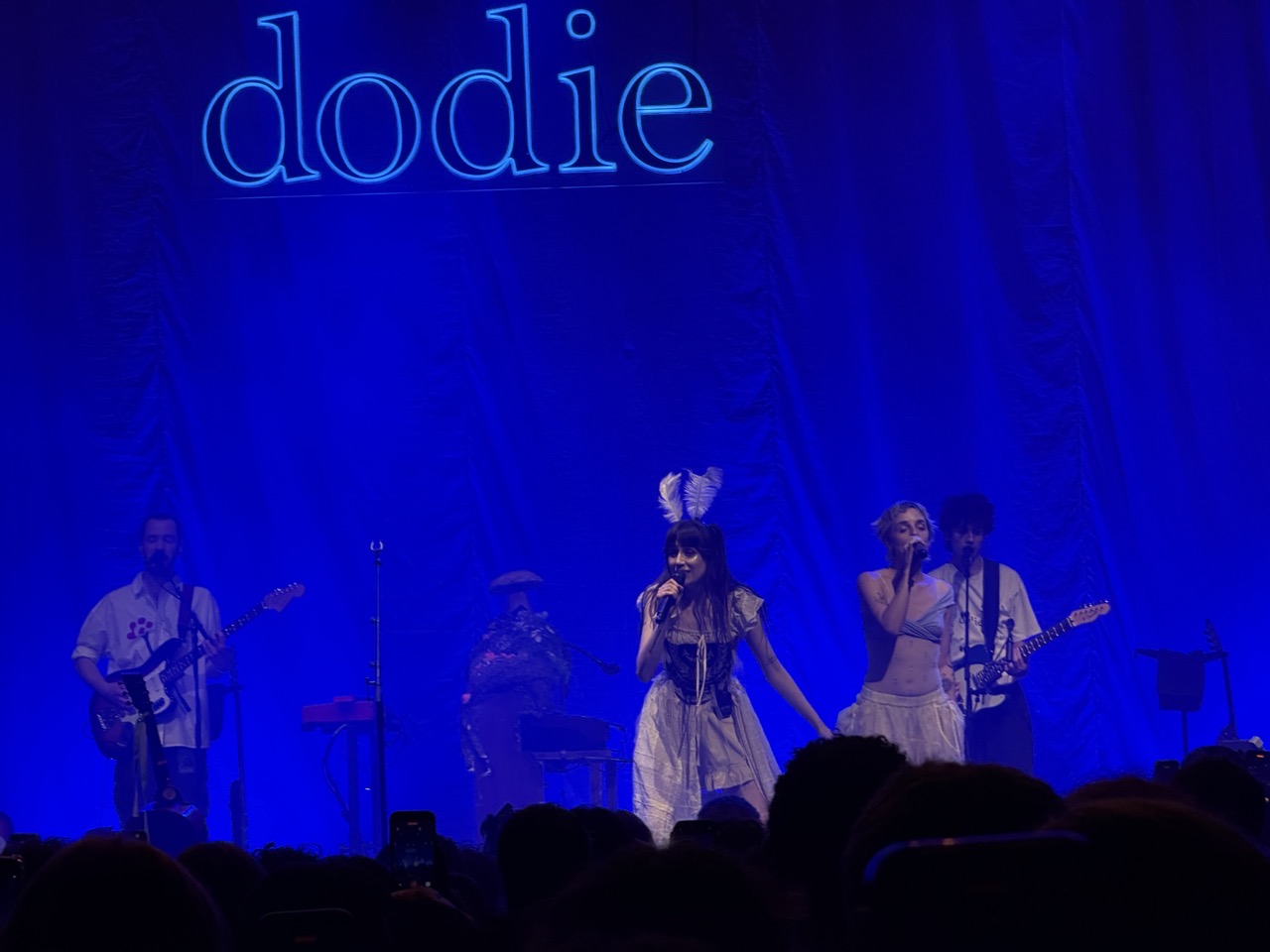 Dodie on stage with band and Greta Isaac