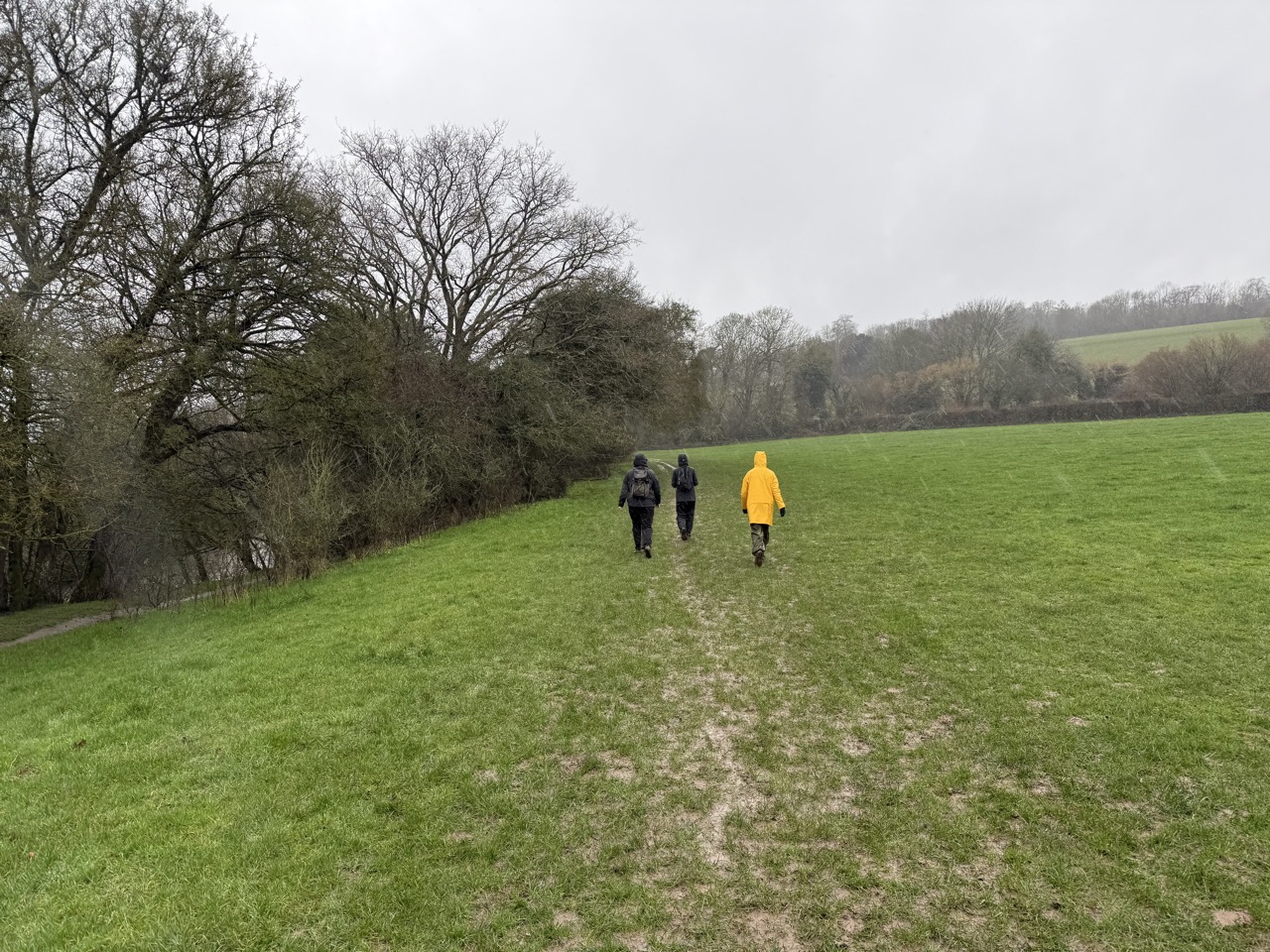 Som pals in a muddy field in the rain